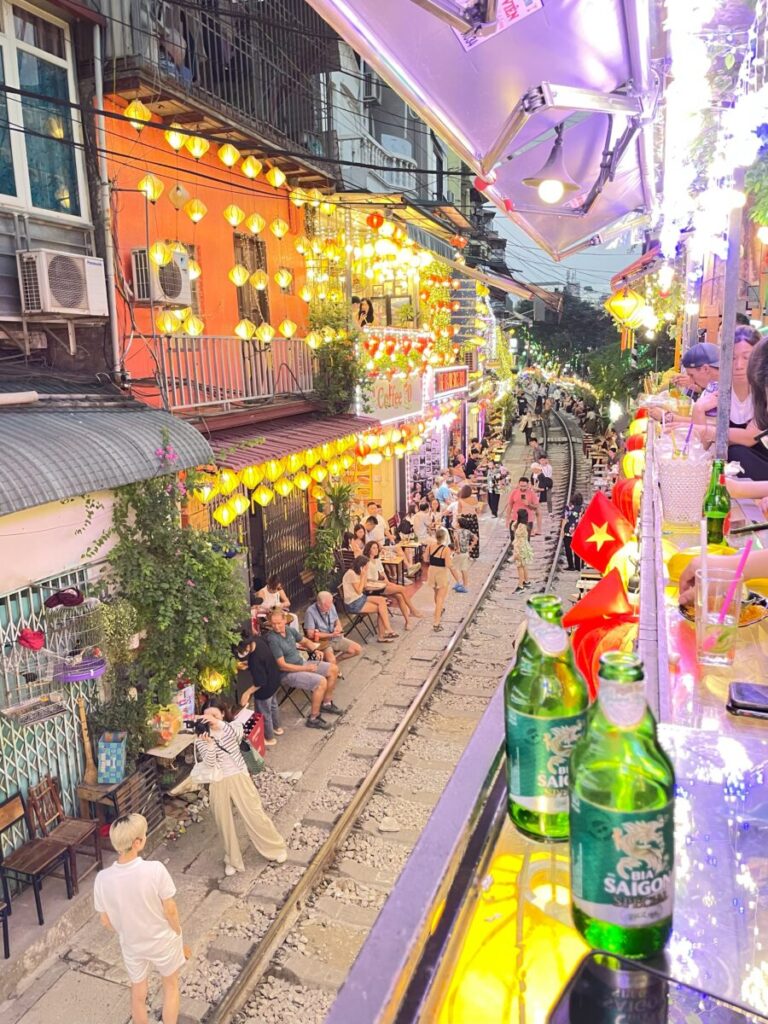 ハノイ旧市街のトレインストリート夜景、線路沿いのカフェと提灯が並ぶ風景