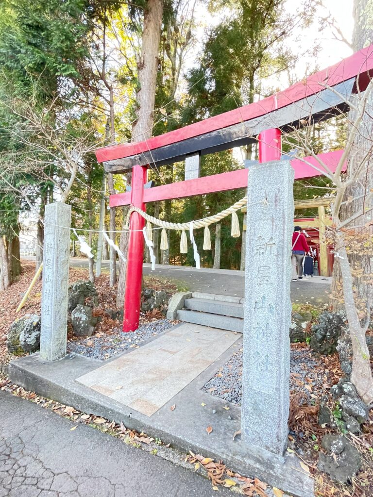新屋山神社の参道入口に建つ赤い鳥居と石柱