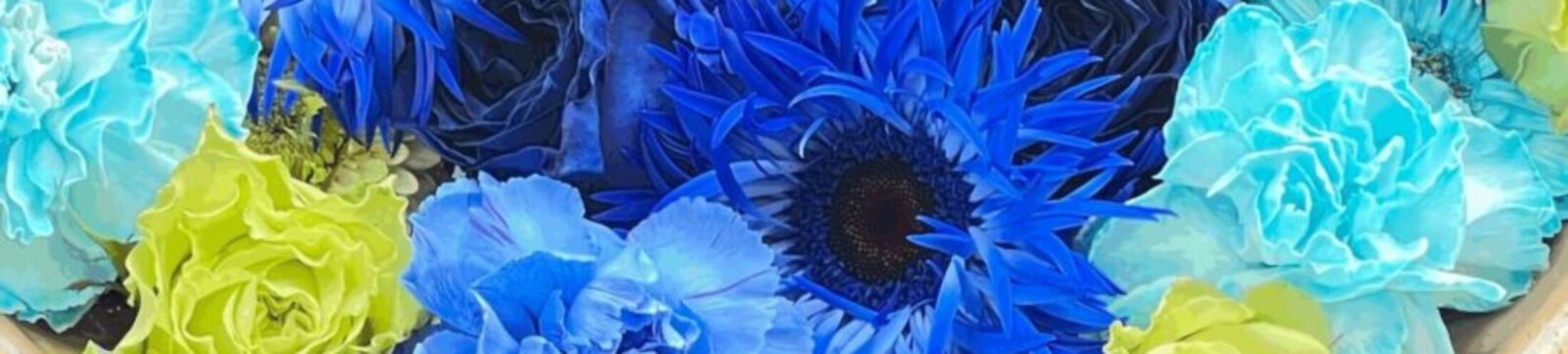 水に浮かべられた青系と黄緑色の花々。爽やかなフラワーボウルの装飾