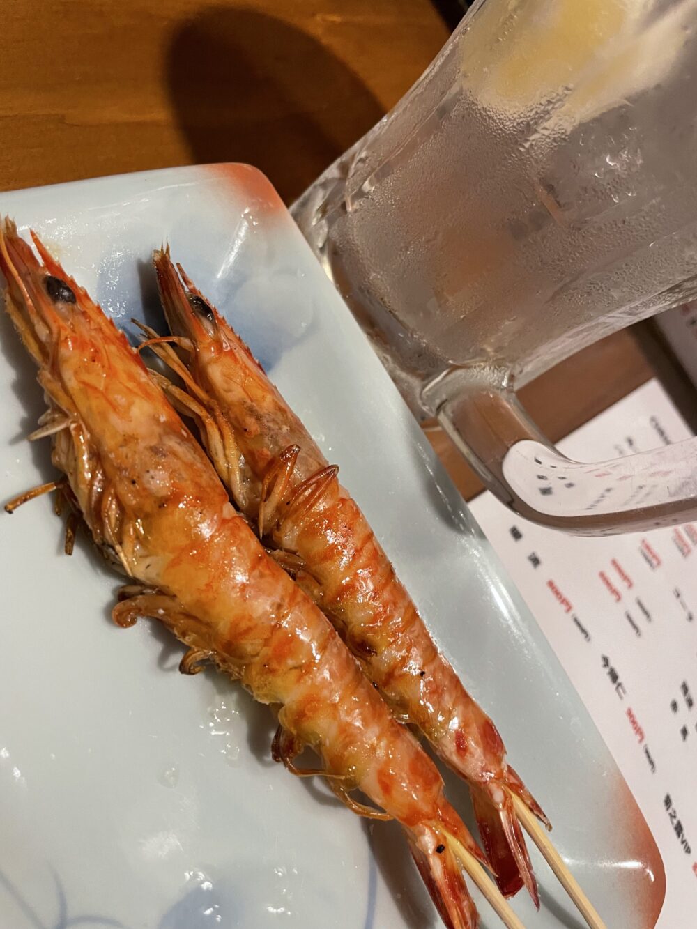 塩焼きされた海老の串とジョッキ