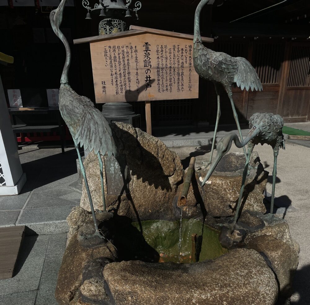 櫛田神社の境内にある鶴の井戸と鶴の像