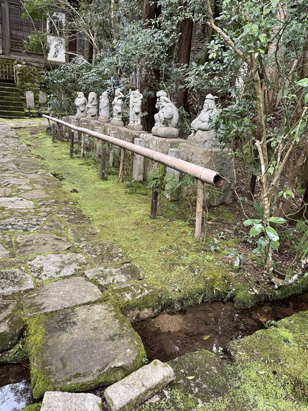 龍潭寺の参道に並ぶ七福神の石像。苔むした境内に佇み、訪れる人を見守っている。
