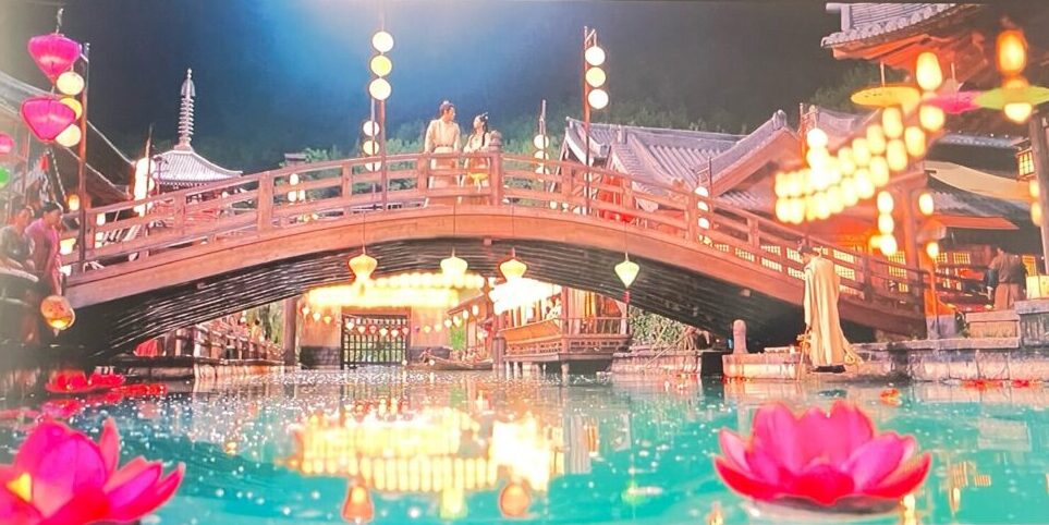 中国ドラマ『浮図縁』の上元節のシーン。橋の上で見つめ合う男女の背後に灯る無数の提灯と、川面に浮かぶ蓮の花が幻想的な雰囲気を演出している。