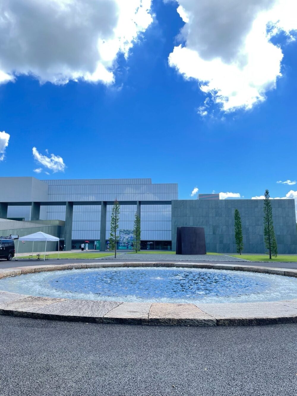 青空の下、噴水越しに見える豊田市美術館の現代的な外観