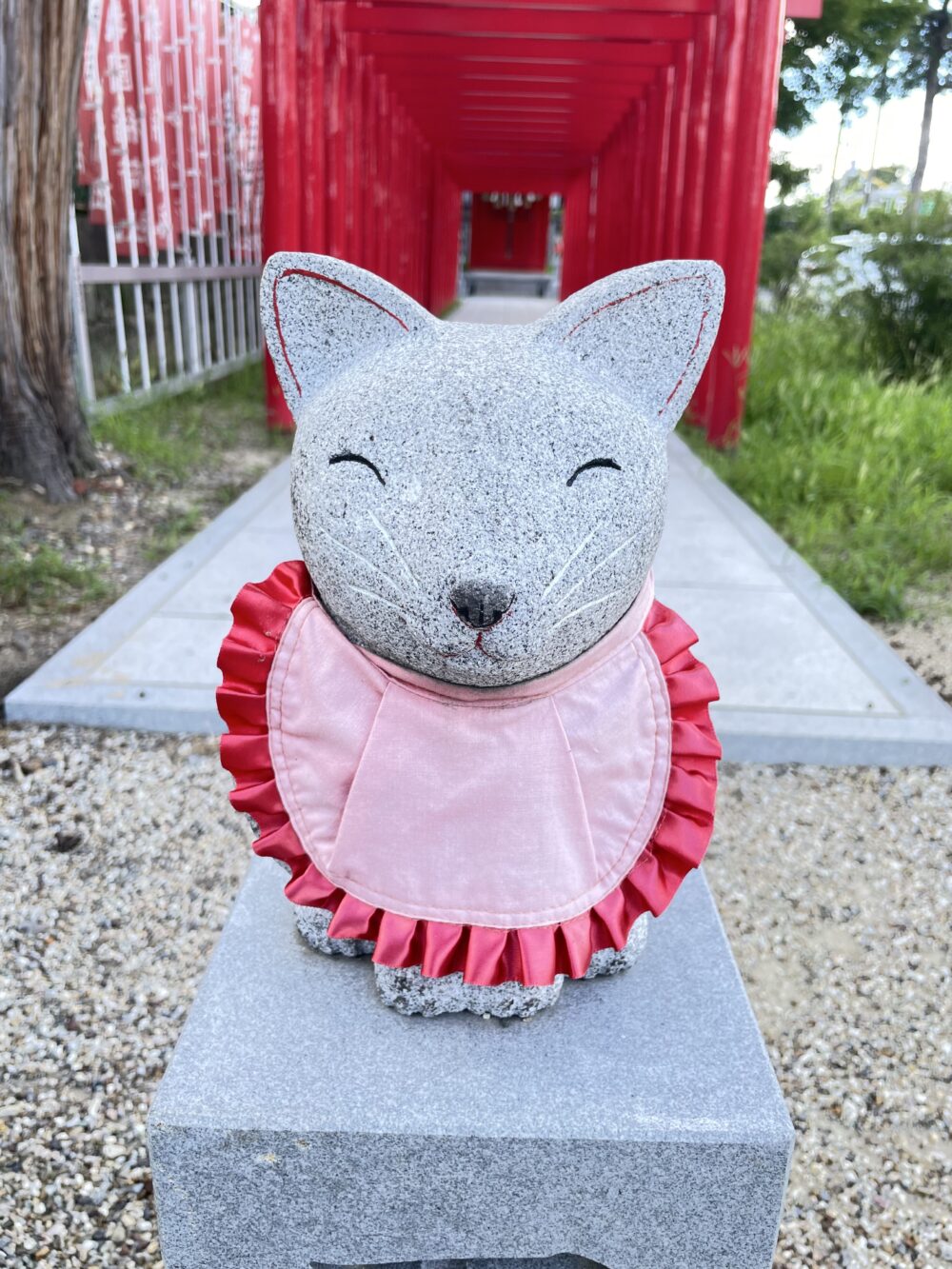 赤い前掛けを着けたお狐さまの石像。 かわいい！