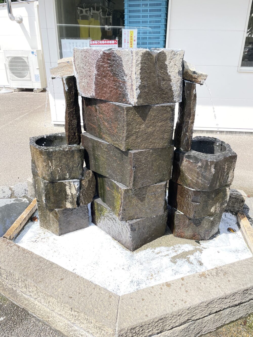 柿田川湧水の水汲み場。石組みから湧き水が流れ、持参した容器に汲めるようになっている。