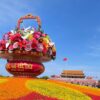 国慶節に飾られる巨大な花籠オブジェと色鮮やかな花畑。背景には天安門が見える。