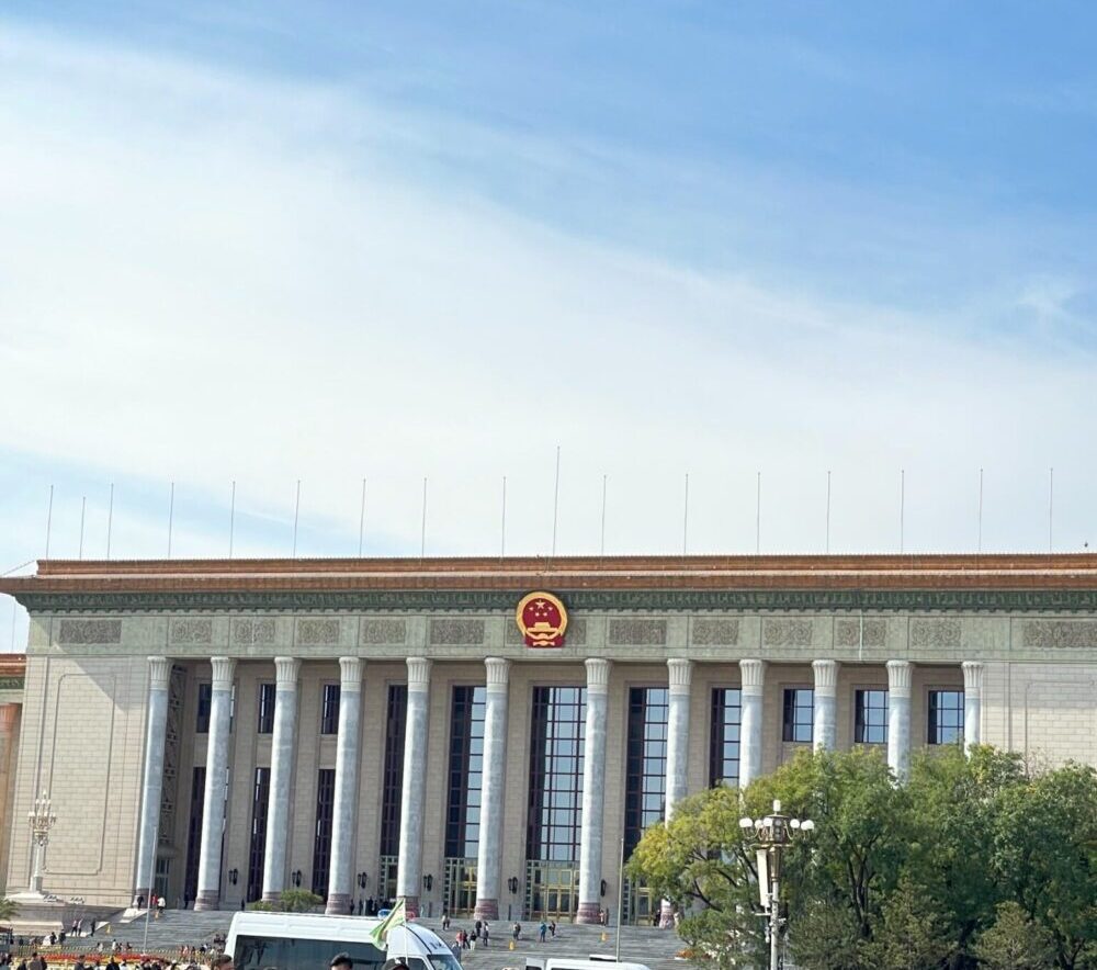 人民大会堂を近くから撮影した写真。入口付近に多くの観光客が集まっている。