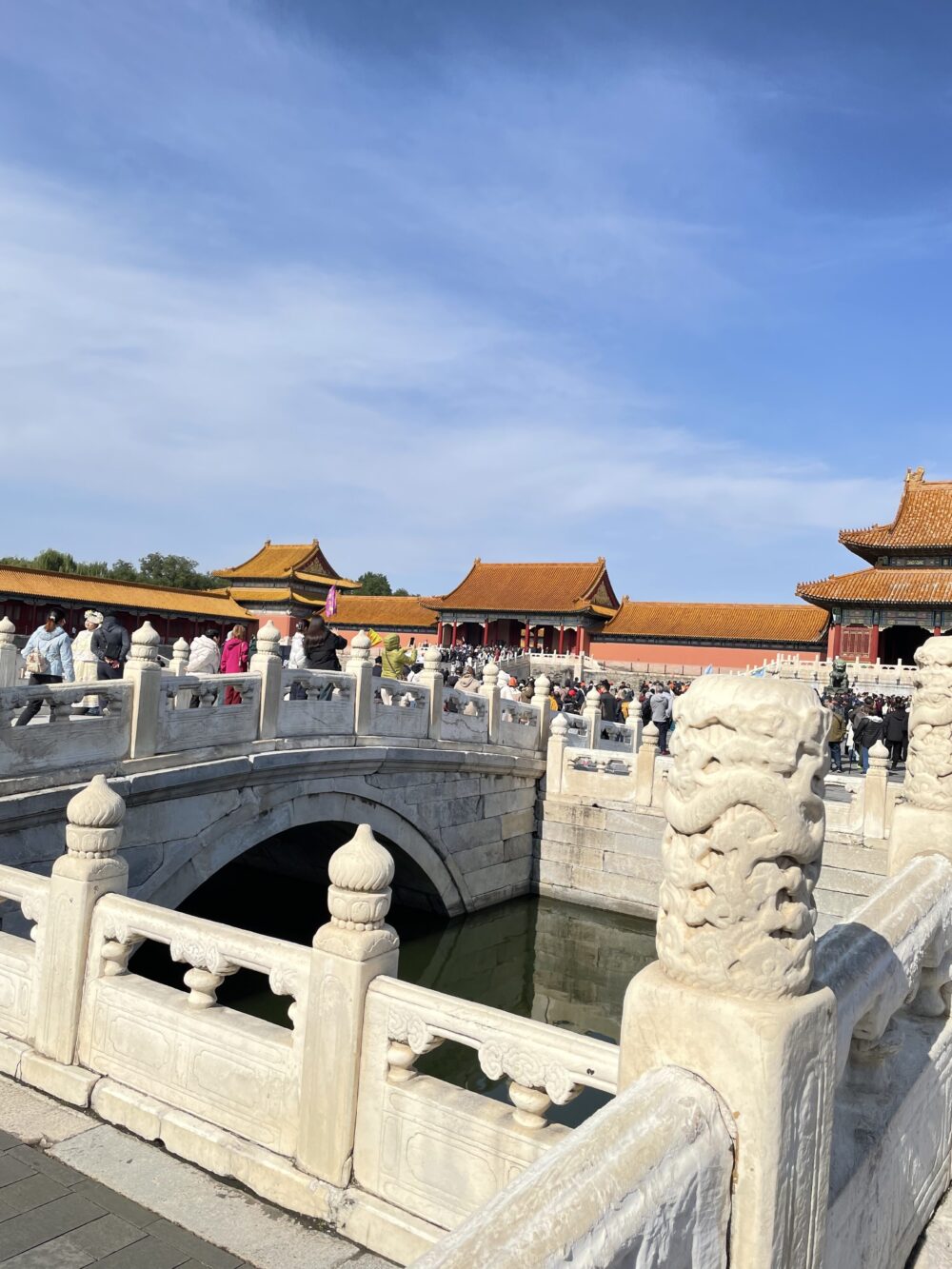 白い大理石の欄干と石橋が架かる太和門前の広場。水路の向こうに金色の屋根の宮殿が並ぶ。