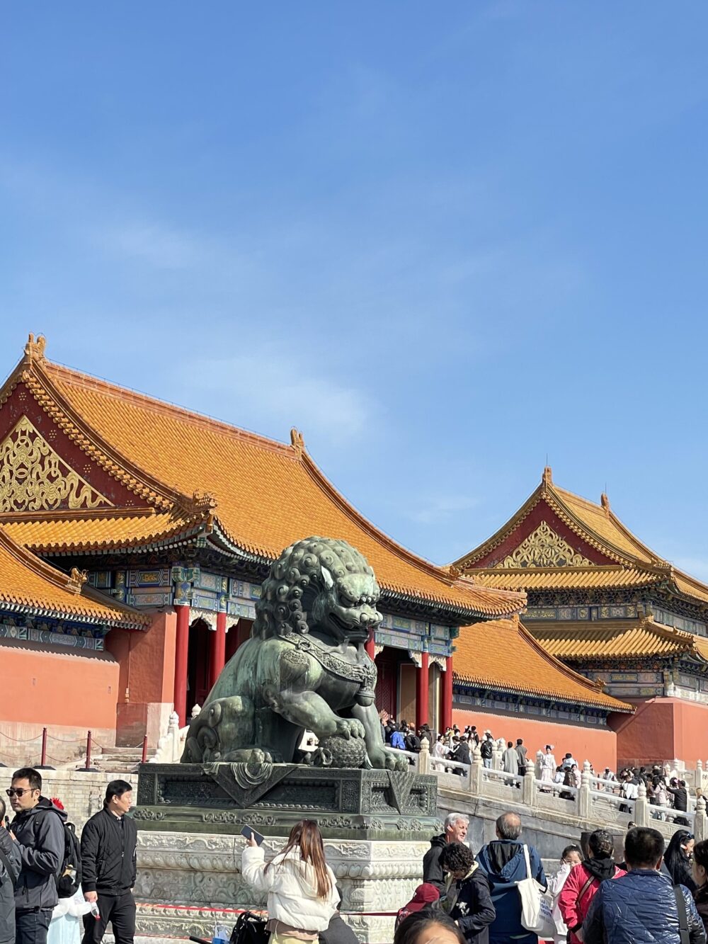 太和門前に置かれた青銅の獅子像。背後には金色の屋根が連なる門建築が広がり、多くの観光客でにぎわう紫禁城の外朝エリア。