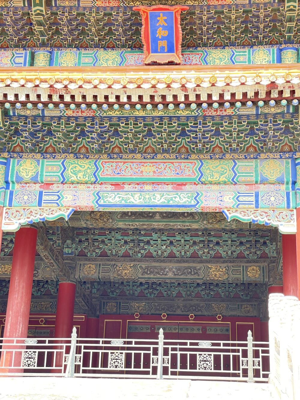 太和門の正面上部。青地に金文字の「太和門」の扁額と、極彩色の斗拱装飾、赤柱が重厚に並ぶ紫禁城の外朝を象徴する門