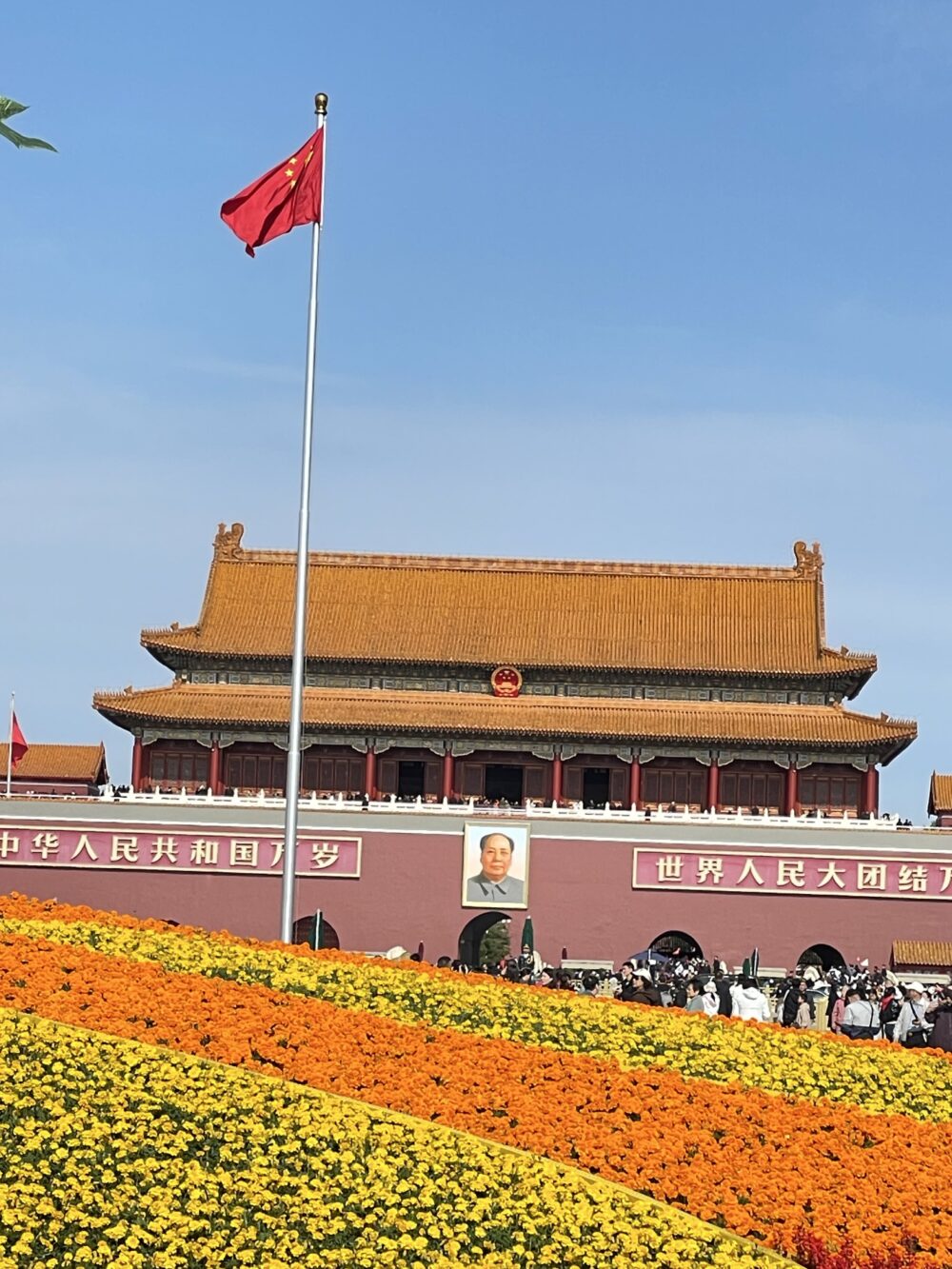 北京・天安門広場の朝、青空の下で国旗が静かに翻る風景