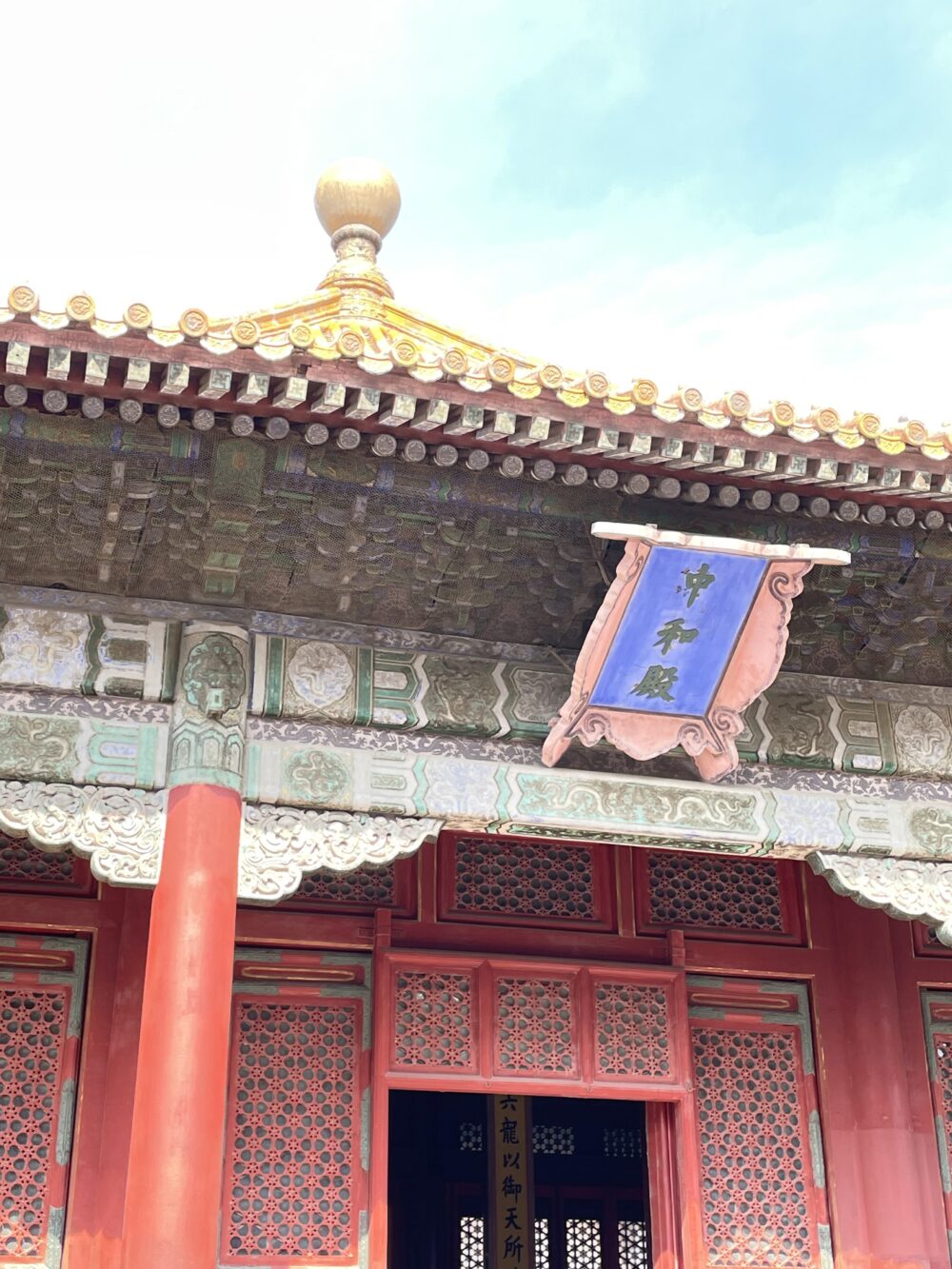 中和殿の扁額を近くから撮影。青地に金文字が映え、斗拱の細かな彩色がはっきり見える。