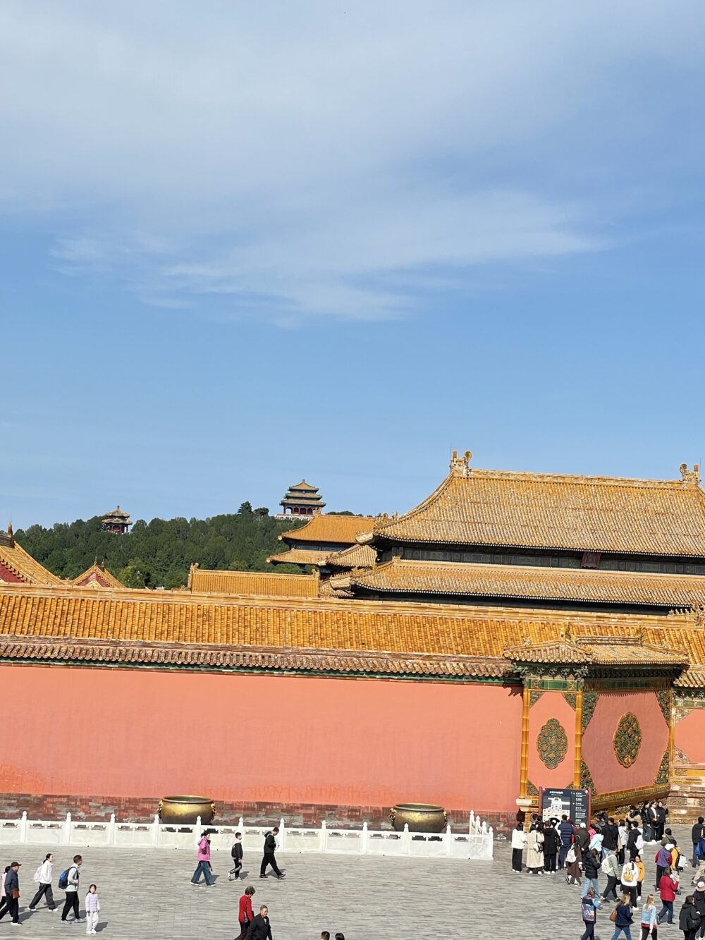 保和殿前の広い石畳と、外側の城壁越しに景山公園の万春亭が見える風景。