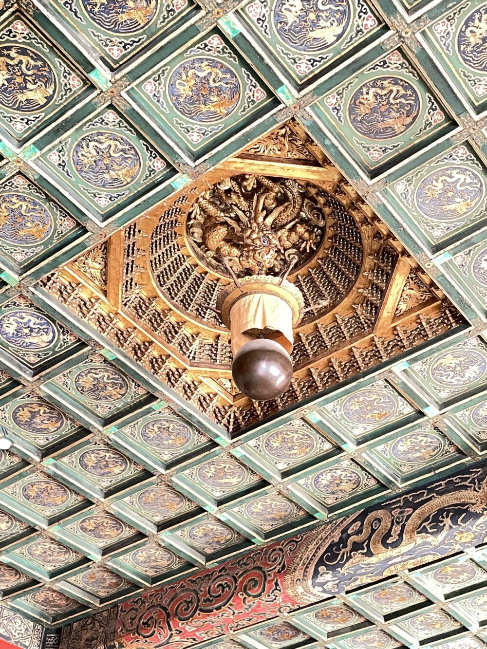 紫禁城・寿康宮の天井装飾。龍の彫刻と格子状の彩色天井、中央に吊るされた宝珠