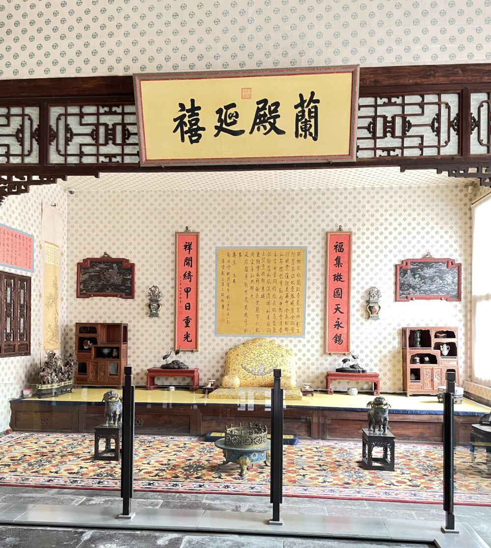 紫禁城・寿康宮の蘭室殿内部。中央に黄色の座榻、左右に対聯と書、清朝皇太后の居室展示