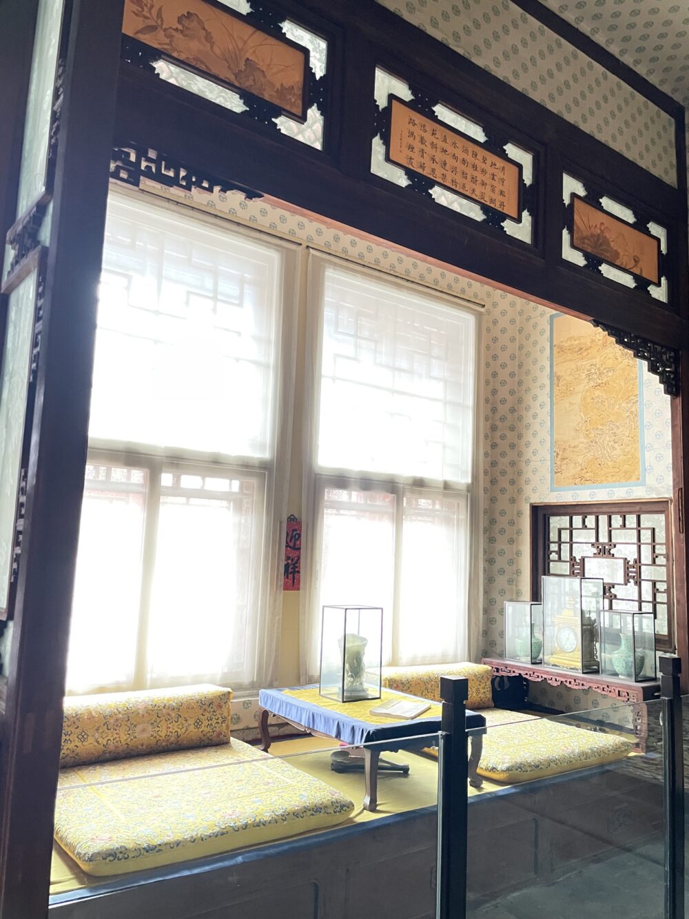 紫禁城・寿康宮の居室内部。窓辺に黄色の座褥と低卓が置かれ、皇太后の生活空間を再現