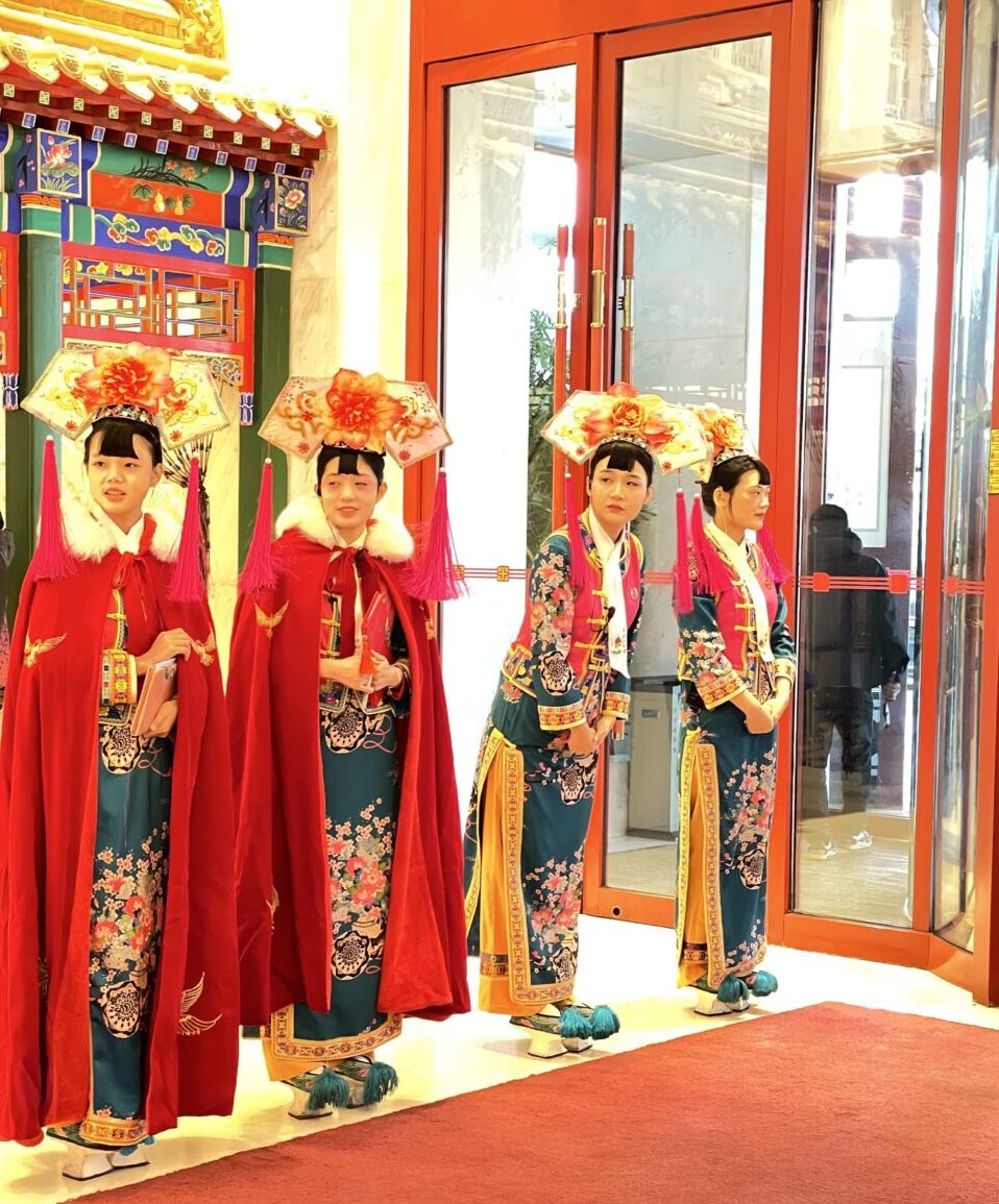 中国皇家菜博物館の入口で迎える清朝宮廷衣装の女性スタッフ（北京）