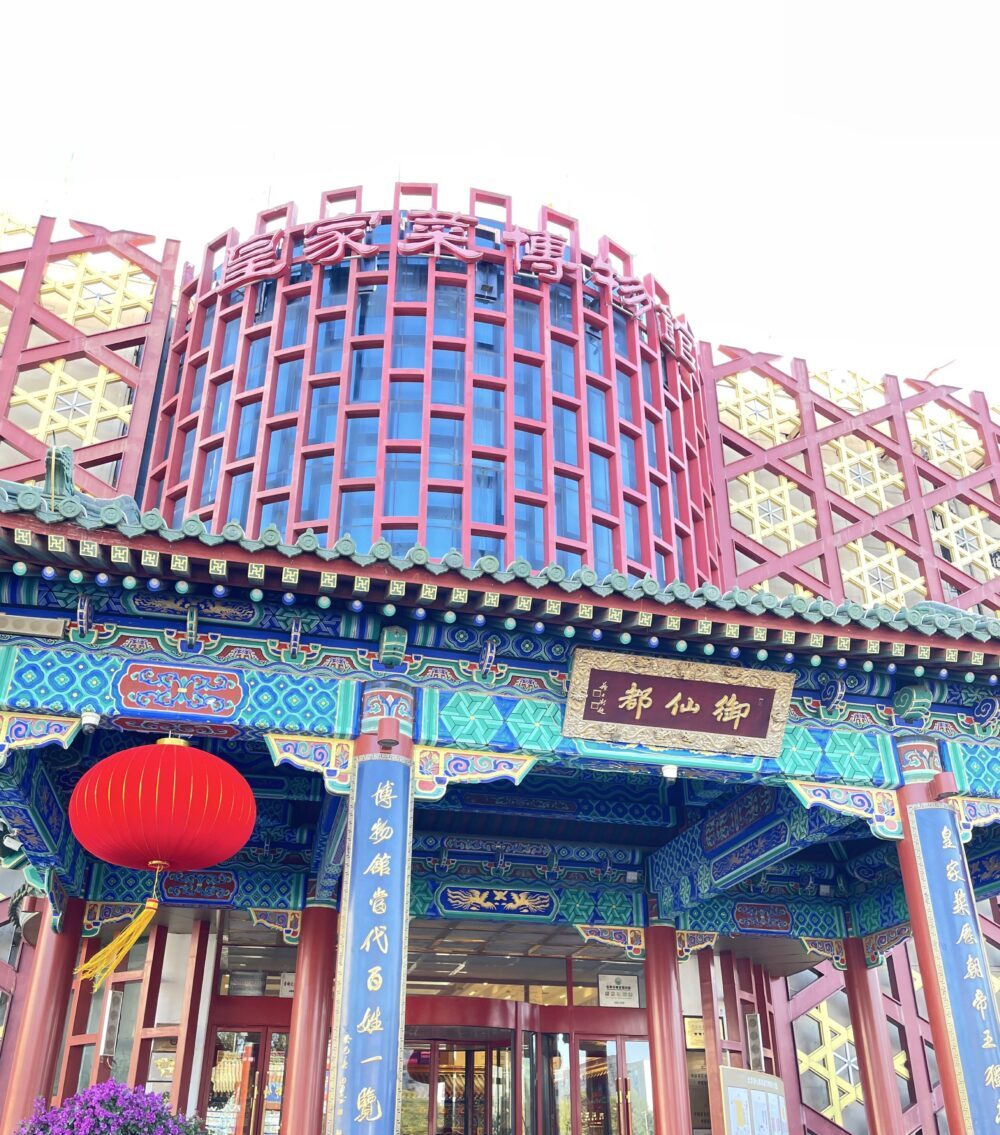 北京御仙都皇家庭菜博物館の外観。伝統的な宮廷建築様式の門構えと赤い提灯が印象的なエントランス。
