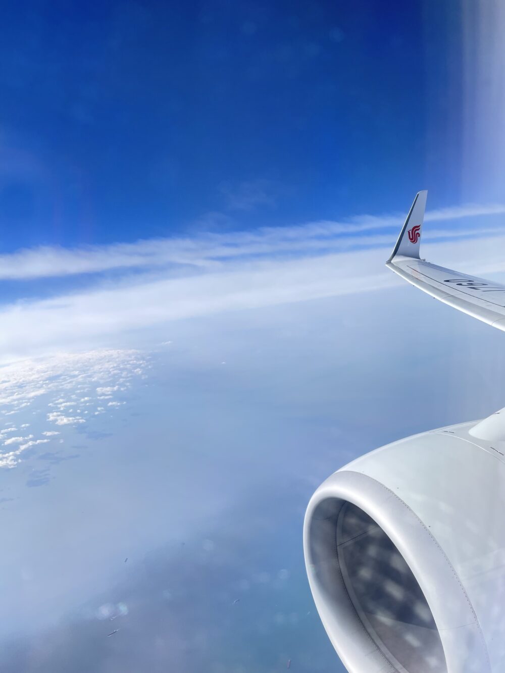 北京から日本へ向かう飛行機の機窓から見た青い空
