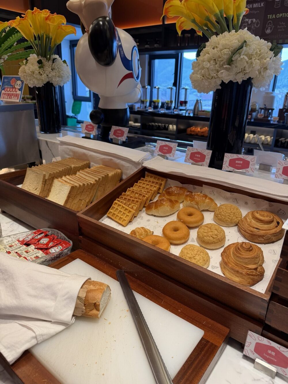 ハンプトン by ヒルトン横店の朝食ビュッフェ。パンやワッフル、ドーナツが並ぶベーカリーコーナー